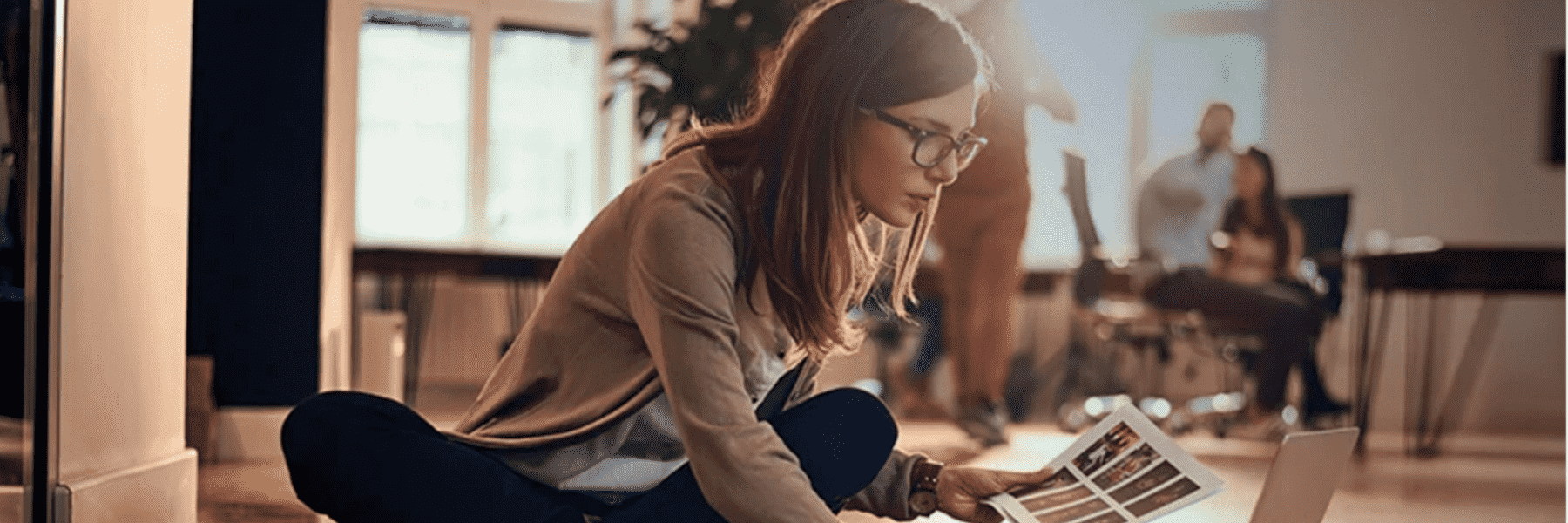 Person on a laptop with documents in hand