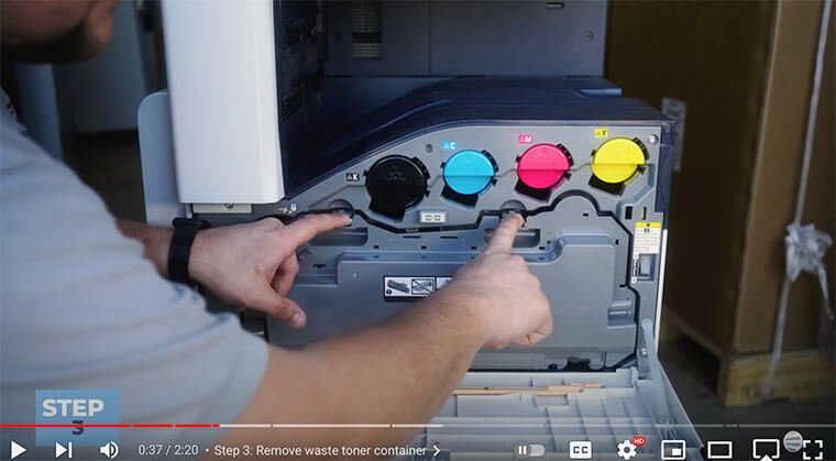Printer technician releases waste toner container on Xerox VersaLink C7000 Series printer