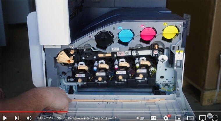 Printer technician points to orange cleaning rod on Xerox VersaLink C7000 Series printer