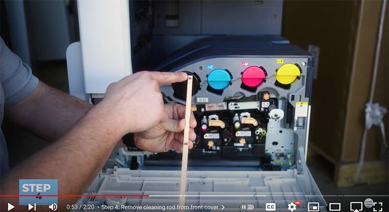 Printer technician points to three felt squares on cleaning rod on Xerox VersaLink C7000 Series printer