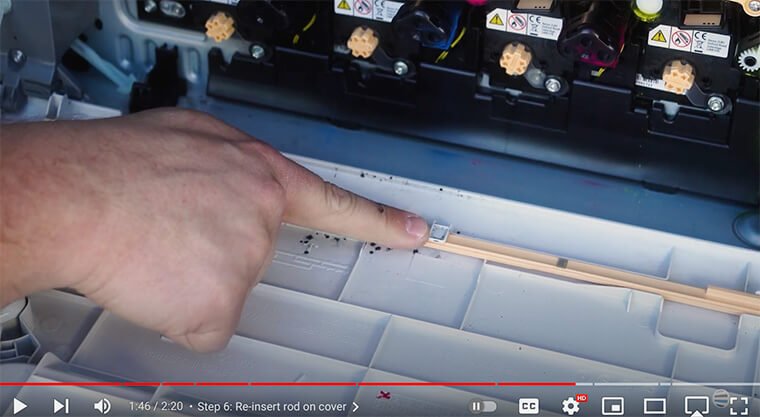 Printer technician re-inserts cleaning rod on Xerox VersaLink C7000 Series printer