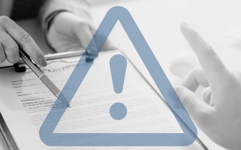 A person about to sign contract with graphic overlay of a warning sign