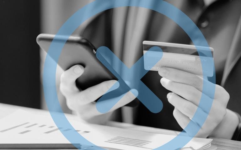 A woman holds her credit card and phone with a graphic overlay of an x