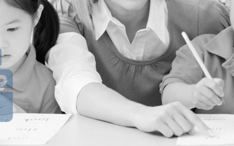 A teacher helping students with paperwork