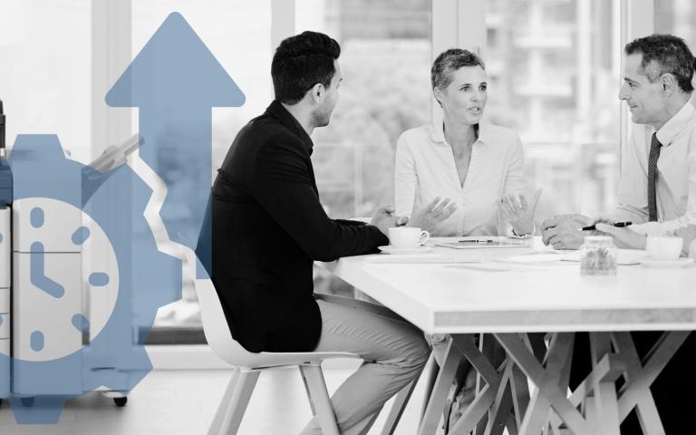 Workgroup sitting on a table talking with a Xerox printer in the background