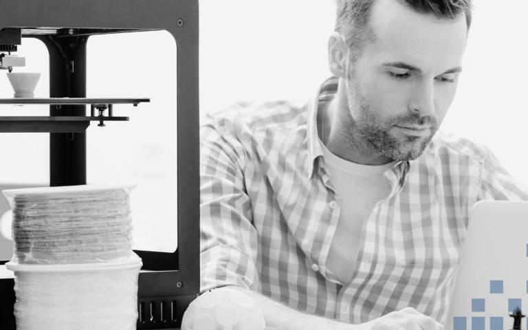 Man using a 3D printer and computer