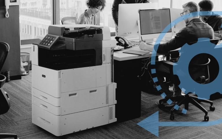 A workgroup in an office working next to a Xerox printer