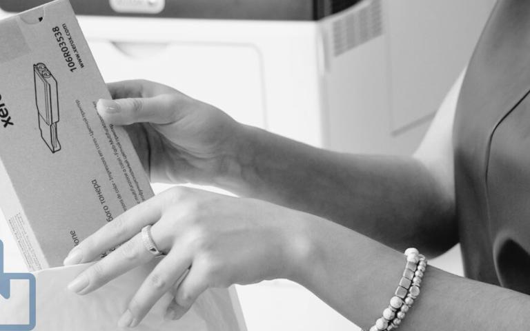 A woman opening a package of printer toner