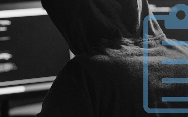 A hacker on a desktop computer with a graphic overlay of a clipboard with a health guard icon