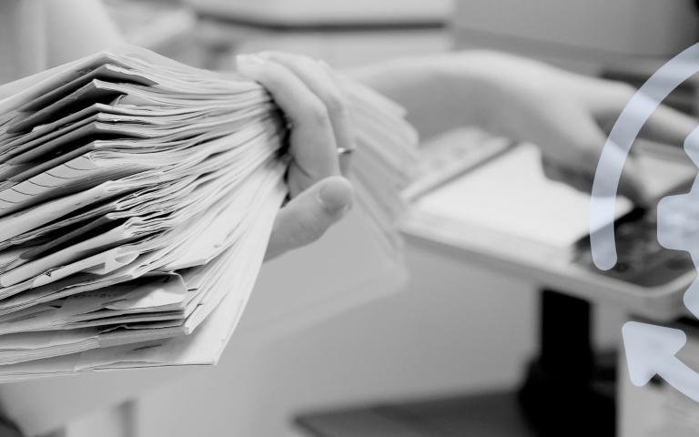 Woman with a stack of papers near a printer