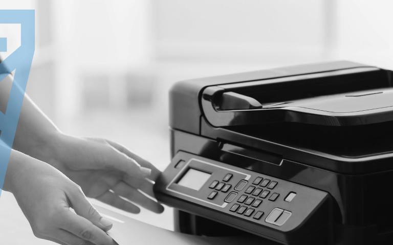 A person retrieving a document from a printer