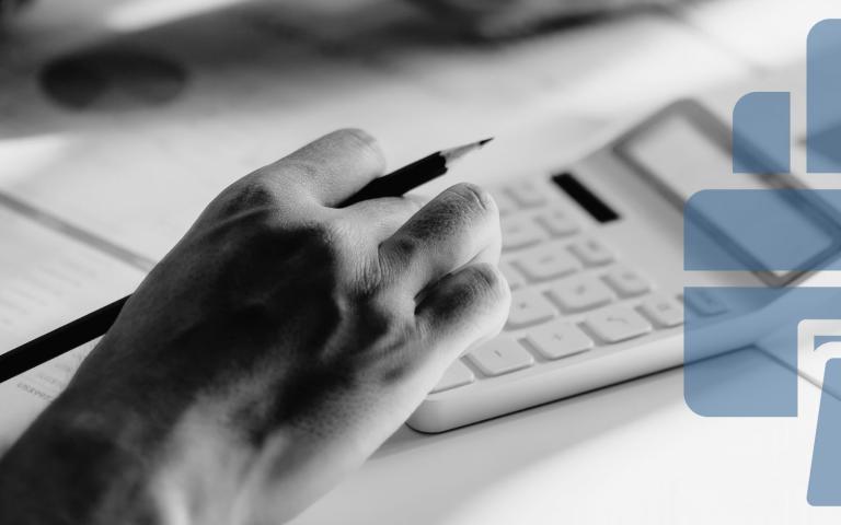 A person on a desk using a calculator