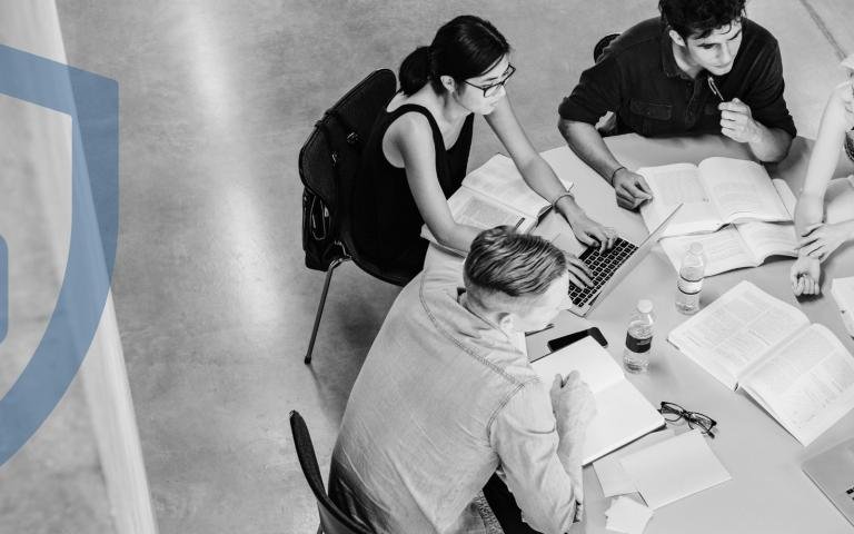 A group of students study in a table with a graphic overlay of a safeguard