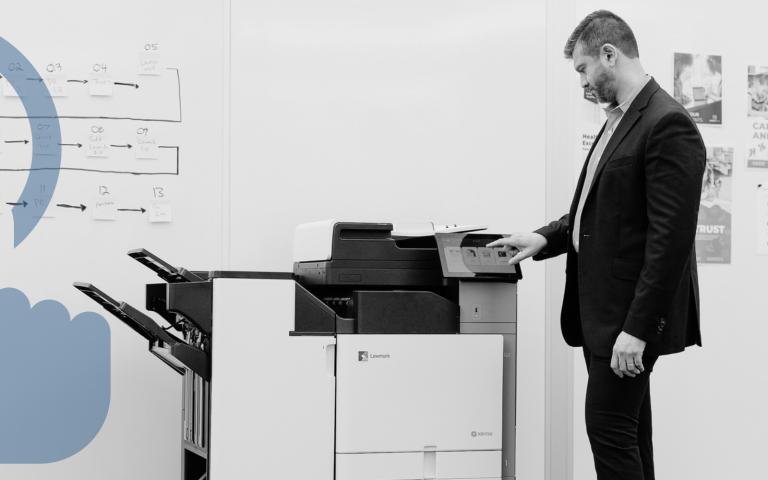 Person using Xerox 9-Series printer in office setting