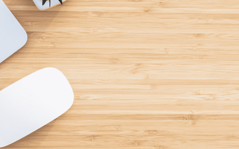 Picture of a desk with a laptop and mouse off to the left