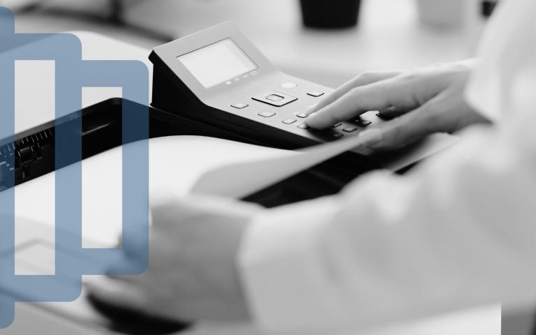 A man using a printer and retrieving a document from it