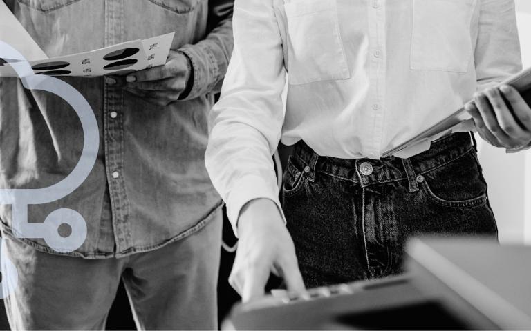 Two office workers using a printer