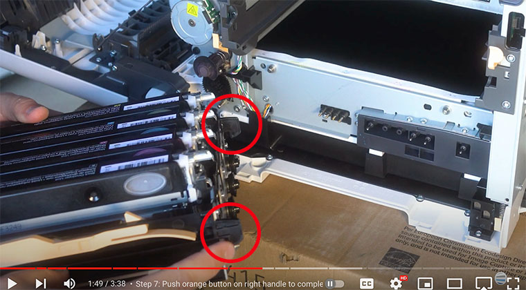 Printer technician points out small black hooks on imaging unit kit of Xerox C410/C415 printer