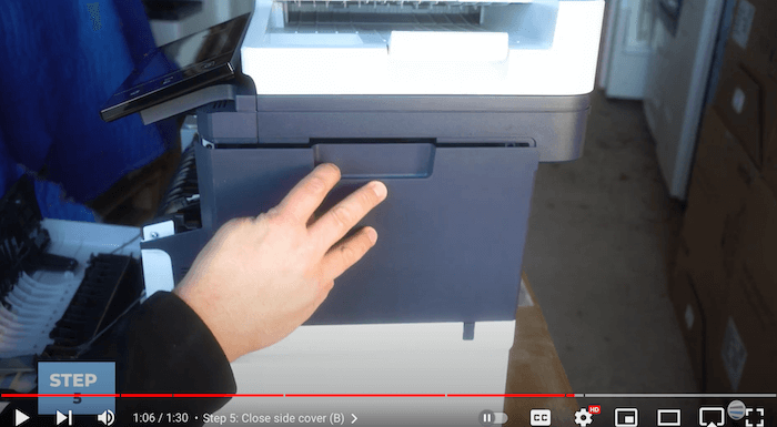Printer technician closes the side cover of the Xerox C410/C415 to replace the toner