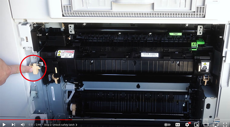 Printer technician points out orange safety latch on the fuser of Xerox AltaLink printer