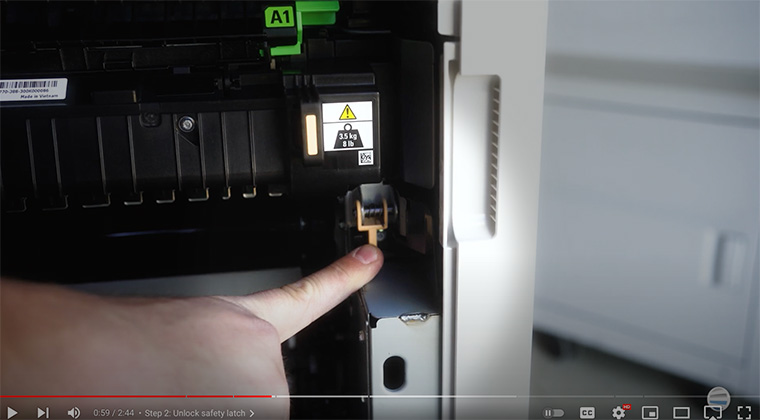 Printer technician points out orange handles on bottom of fuser of Xerox AltaLink printer