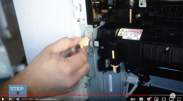 Printer technician locks orange safety latch on the fuser of Xerox AltaLink printer