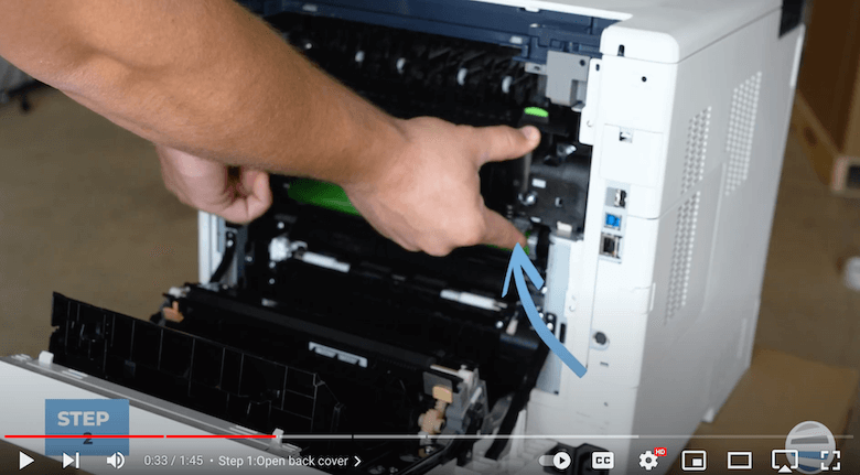 A printer technician pulls on the fuser to remove it on a Xerox printer