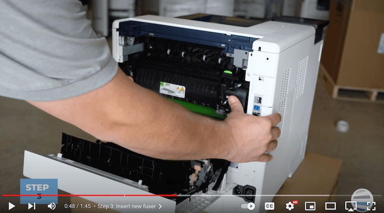 A printer technician pushes in the new fuser on a Xerox printer