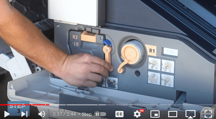 Printer technician unlocks the orange latch on the Xerox AltaLink B8090 Printer to replace print cartridge