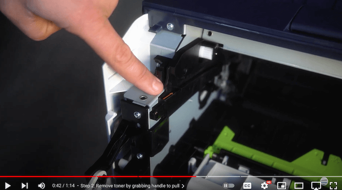 Printer technician points to the orange arrows inside the toner compartment on the Xerox B410/B415 printer to replace the toner