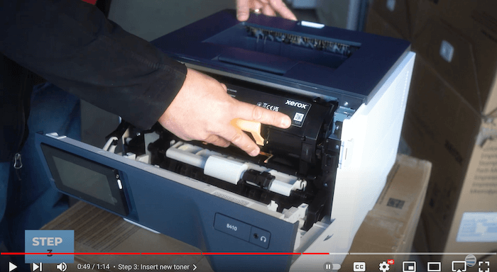 Printer technician slides the new toner cartridge into the Xerox B410/B415 printer to replace the toner