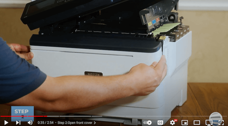 A printer technician opens the front cover on the Xerox C315
