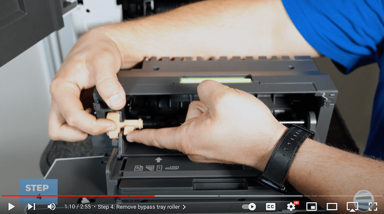 A printer technician removes the old bypass tray roller kit of the VersaLink B625