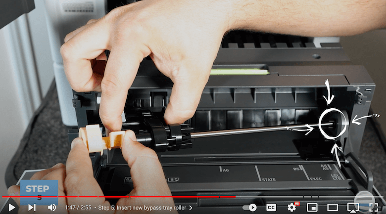 A printer technician aligns the new bypass tray roller kit on the VersaLink B625